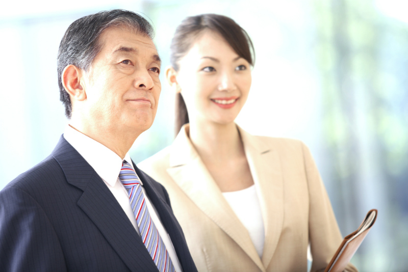 笑顔を見せる社長と秘書